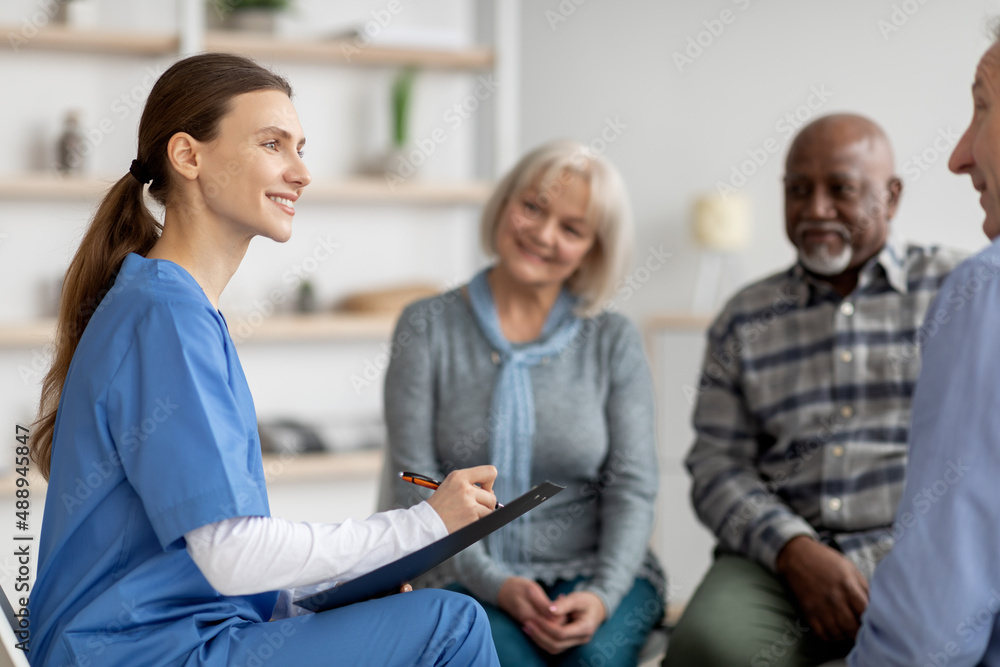 Friendly young woman doctor having conversation with senior people Friendly young woman doctor having conversation with senior people