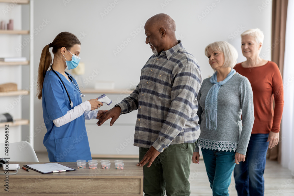 Fototapeta premium Multiracial group of senior people checking body temperature