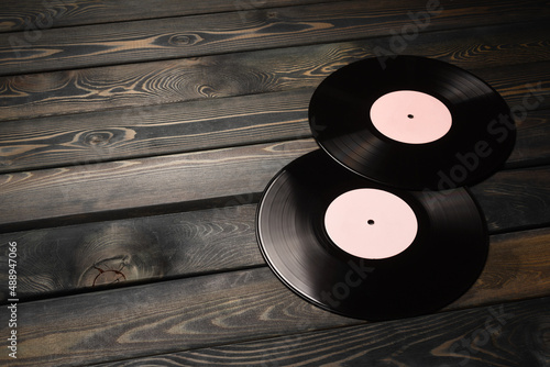 Vinyl records on the old wooden table background with copy space close up.