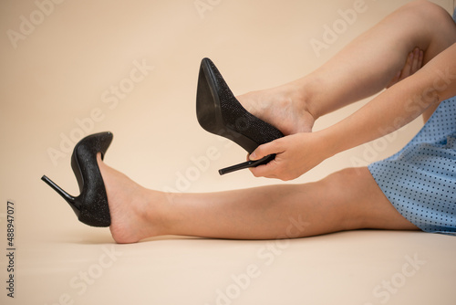 Wrong size of shoes. Woman is trying on a new high heels shoes in the footwear store close up.