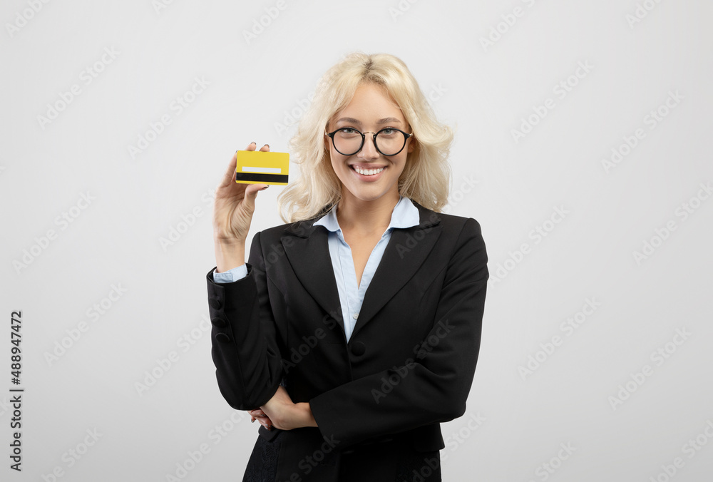 Excited female bank worker holding credit card and smiling at camera, recommending fast money transfers Excited female bank worker holding credit card and smiling at camera, recommending fast money transfers