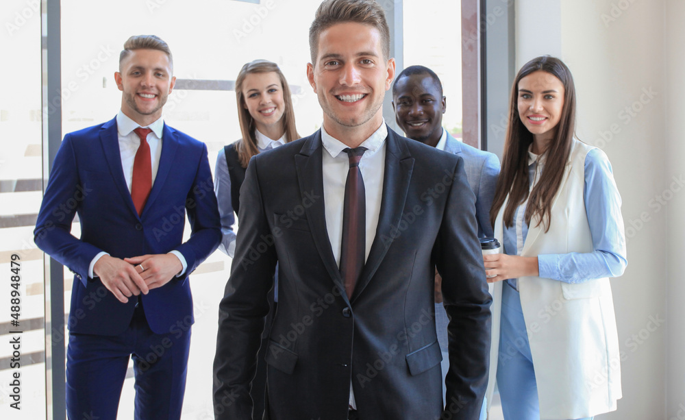 Happy smart business man with team mates discussing in the background. Happy smart business man with team mates discussing in the background.