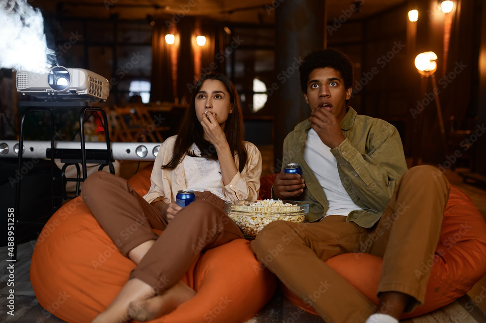 Young couple watch movie film on projector