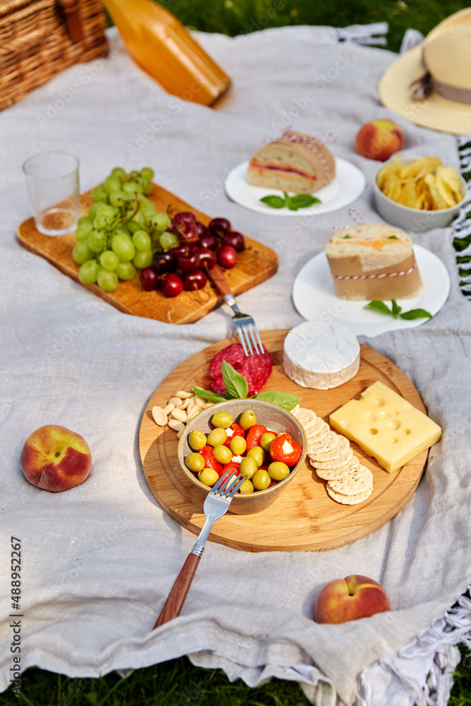 leisure and eating concept - close up of food, drinks and picnic basket on blanket at summer park leisure and eating concept - close up of food, drinks and picnic basket on blanket at summer park