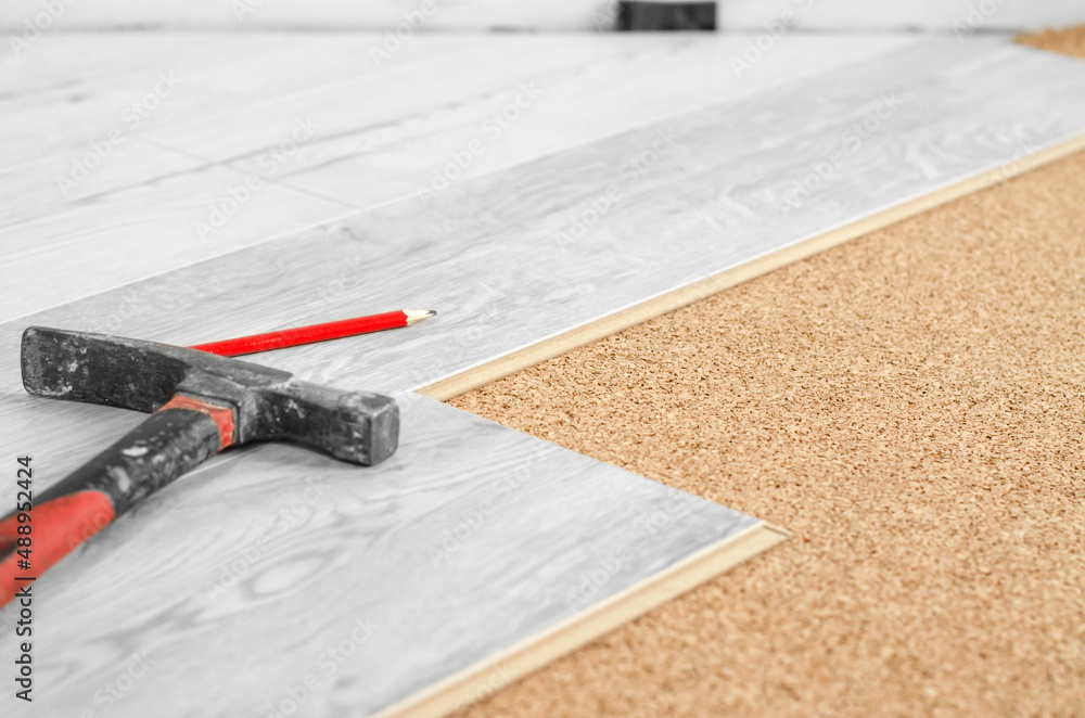 Professional laying of a floor covering a laminate. Laying laminate on a cork base and tools