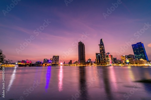 View of Bitexco Financial Tower building, buildings, roads, Thu Thiem bridge and Saigon river in Ho Chi Minh city in sunset.