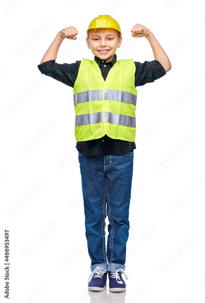 building, construction and profession concept - happy smiling little boy in protective helmet and safety vest showing power gesture over white background
