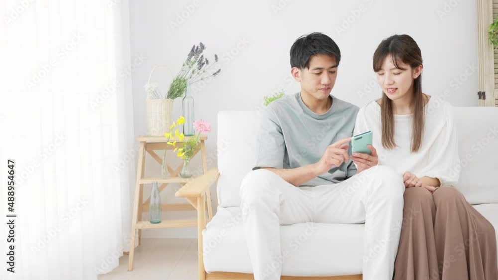 スマートフォンを使う若い男性と女性 スマートフォンを使う若い男性と女性