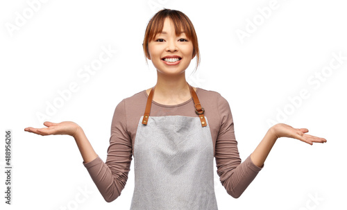 cooking, culinary and people concept - happy smiling female chef or waitress in apron over white background