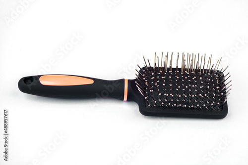 Massage comb for combing hair. Plastic brush with metal corners for detangling hair. On an isolated white background.close-up.