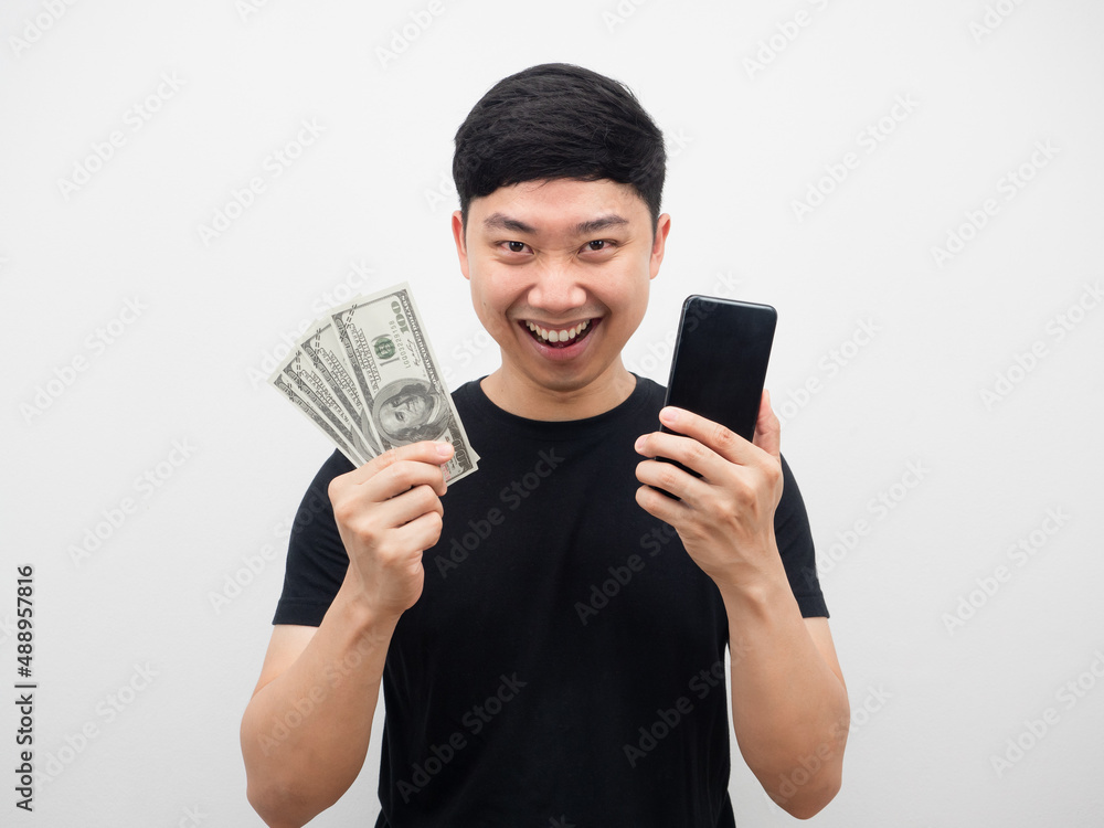 Asian man holding money and phone feeling happy white background Asian man holding money and phone feeling happy white background