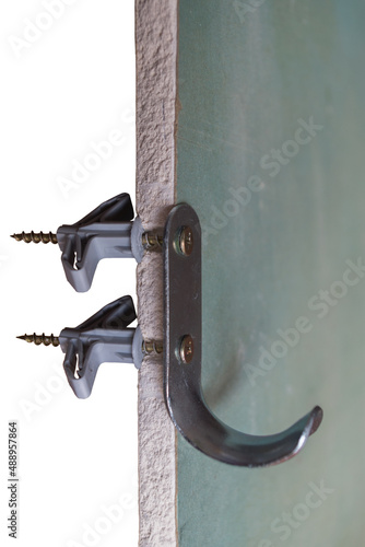 Cut of moisture-resistant plasterboard, demonstrating  installation of metal hook on wall partition with two plastic butterfly dowels with screws screwed into anchors in state of fixation, isolated.