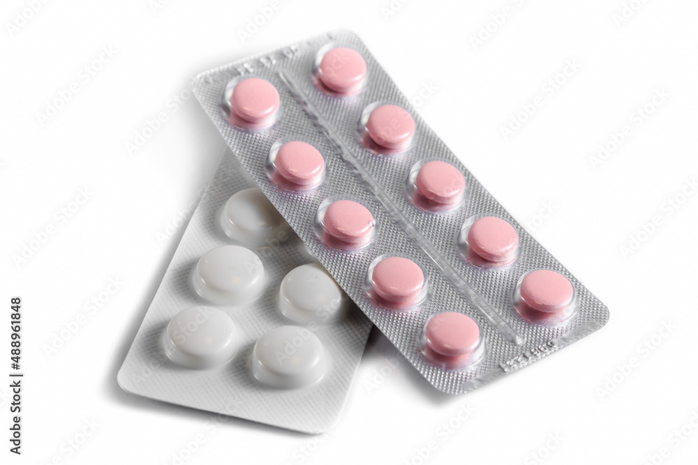 Close-up of a couple white pills or capsules on isolated white background. Close-up of a couple white pills or capsules on isolated white background.