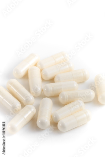Close-up of a couple white pills or capsules on isolated white background.