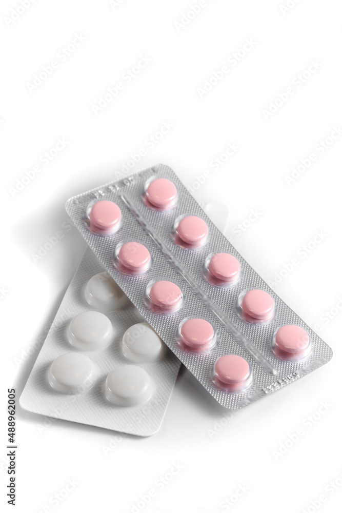 Close-up of a couple white pills or capsules on isolated white background. Close-up of a couple white pills or capsules on isolated white background.