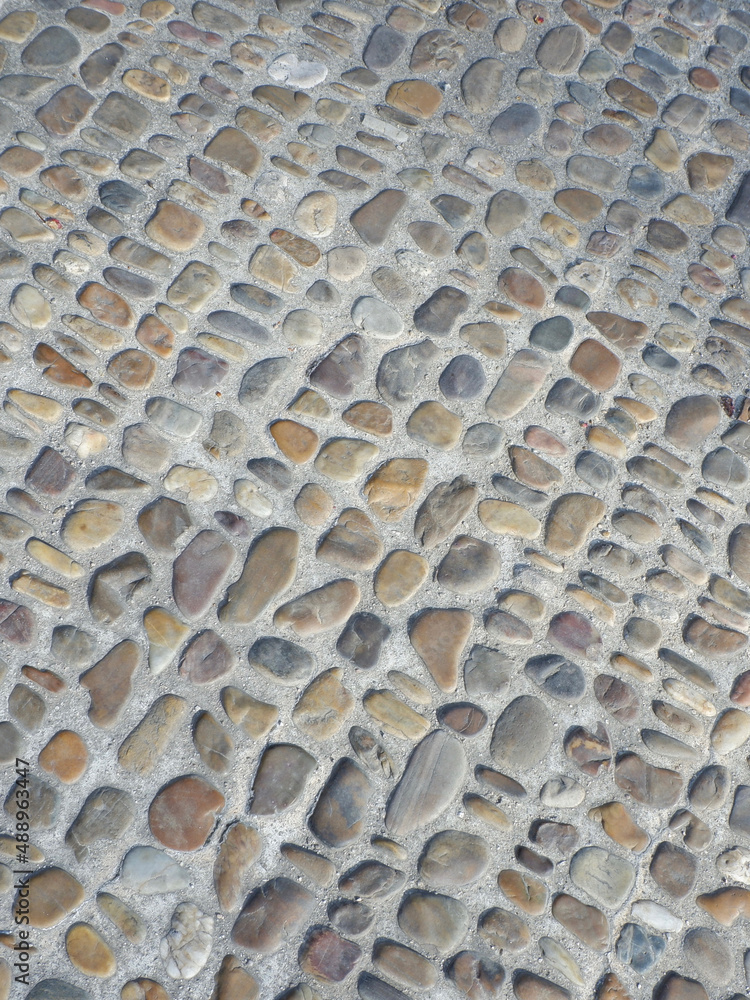 Pavement made of rounded sea stone. Sidewalk covered with natural materials