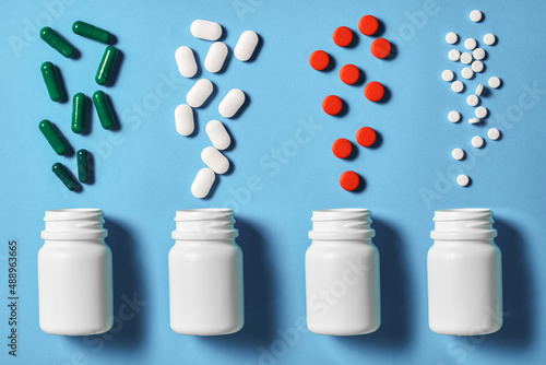 different forms of pills are poured from vials. Variety of appearance of drugs. Top view