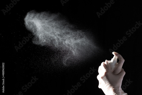 Bild auf Leinwand Female hands in protective gloves hold a plastic spray bottle with a chemical