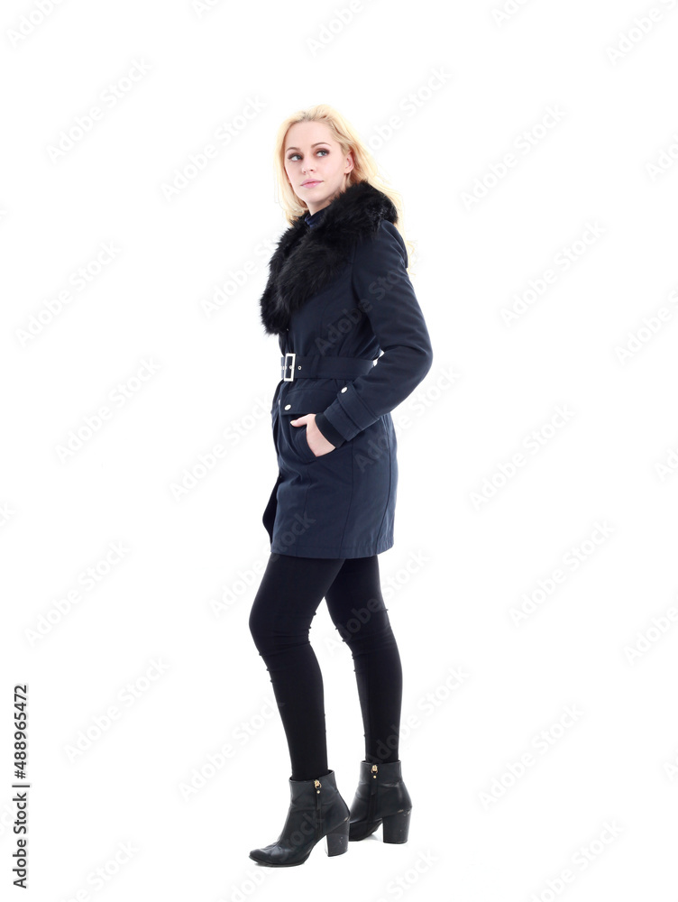 full length portrait of blonde woman wearing long winter coat. and casual clothes. standing pose, isolated on a white studio background.