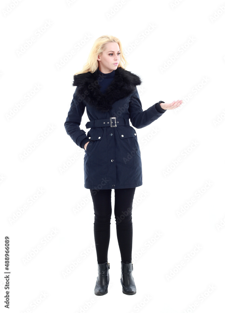 full length portrait of blonde woman wearing long winter coat. and casual clothes. standing pose, isolated on a white studio background.