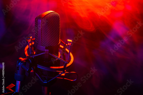 Professional microphone in red blue smoke on a black background.