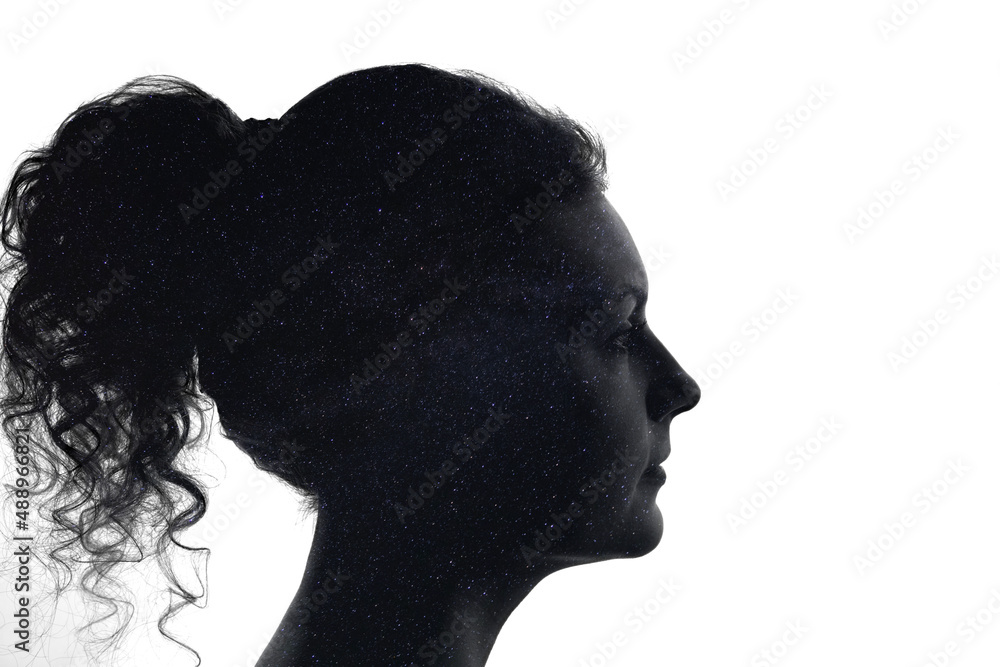 Silhouette of a woman's face filled with night starry sky, milky way.