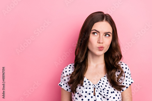 Portrait of attractive cunning wavy-haired woman overthinking copy space pout lips isolated over pink pastel color background