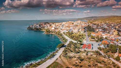 Fototapeta Naklejka Na Ścianę i Meble -  Aerial view of houses and villas in a resort town Neos Marmaras in Sithonia, Halkidiki, Greece with basketball playground. Real estate and urban development concept