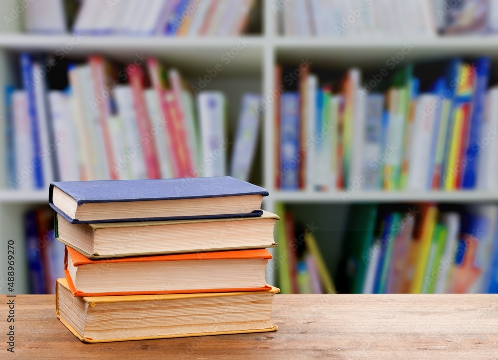 Stack of books on the table in the library background Stack of books on the table in the library background