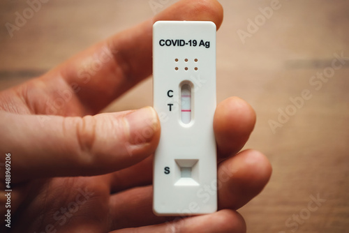 Man holding Positive Antigen Rapid Test for Coronavirus.