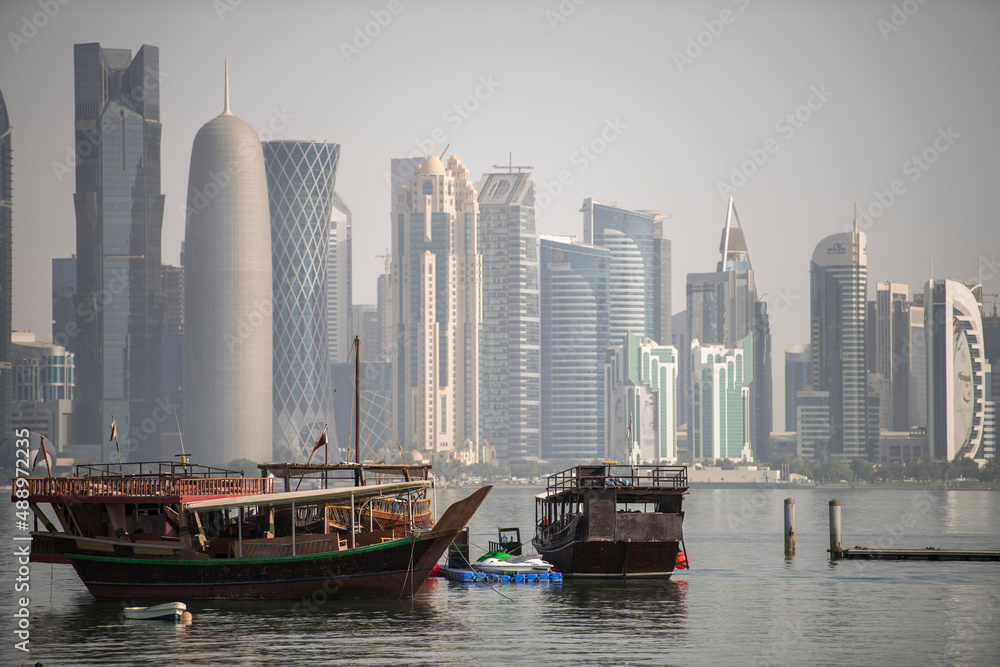 Fototapeta premium Doha,Qatar- December 23,2018 : Traditional dhow boats with the futuristic skyline of Doha in the background.
