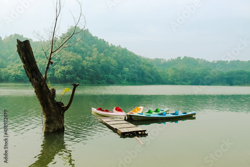 Kayak boat on the river that flows near the hilly forest 
