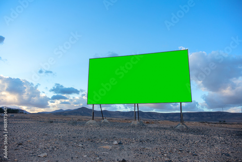 Billboard blank in a deserted landscape | Green screen with copy space