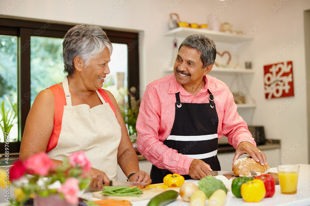 Cooking with love. Shot of a happy senior couple cooking a healthy meal together at home. Cooking with love. Shot of a happy senior couple cooking a healthy meal together at home.