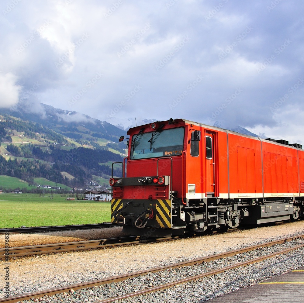 Obraz premium Old fashioned red train in austrian Alps on summer