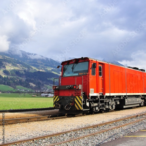 Old fashioned red train in austrian Alps on summer