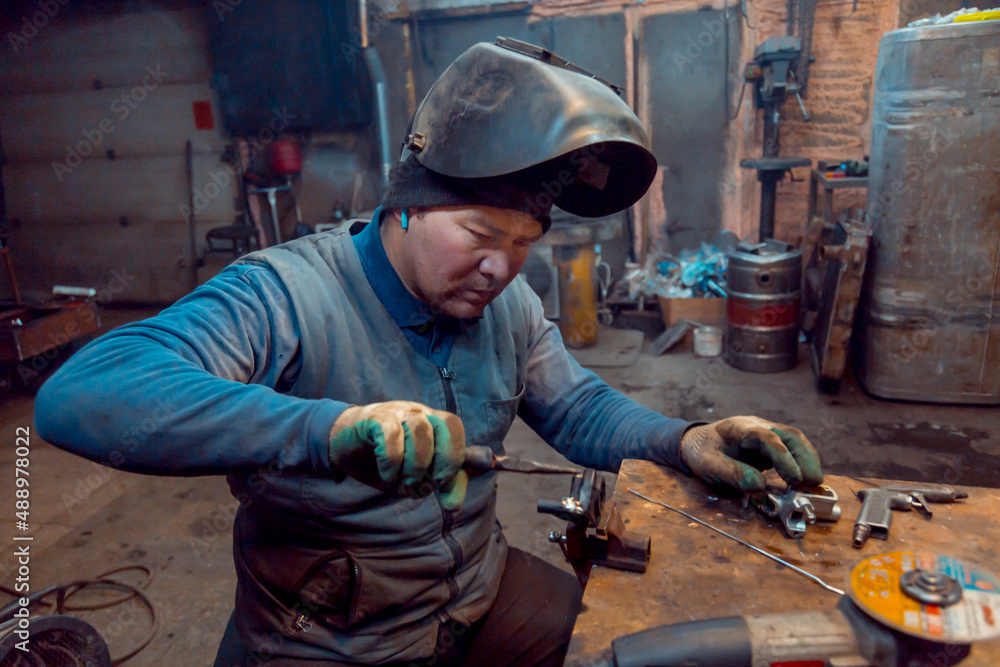 Portrait of a welder with a microphone in his ear at the workplace Portrait of a welder with a microphone in his ear at the workplace