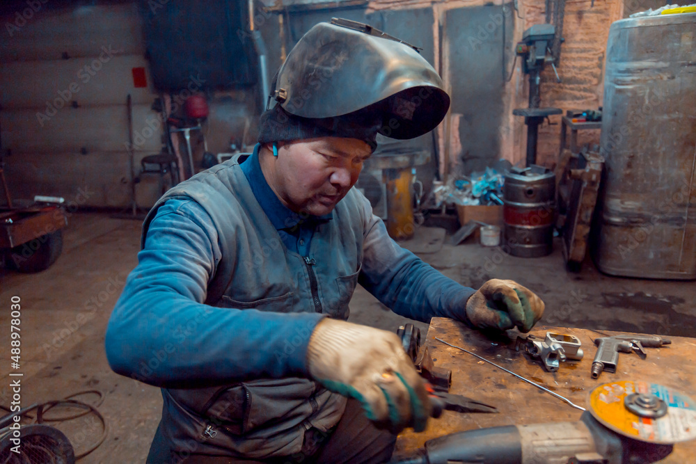 Portrait of a welder with a microphone in his ear at the workplace Portrait of a welder with a microphone in his ear at the workplace