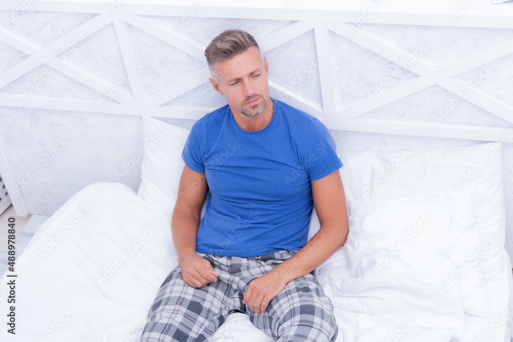Carried away by daydream. Thoughtful guy daydream in bed. Pajama man daydreaming. Morning relaxation Carried away by daydream. Thoughtful guy daydream in bed. Pajama man daydreaming. Morning relaxation