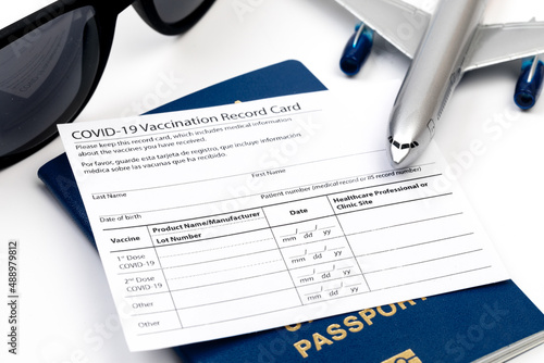 COVID-19 vaccination record card and tourist passport of traveler for worldwide travel during coronavirus pandemic. - Image