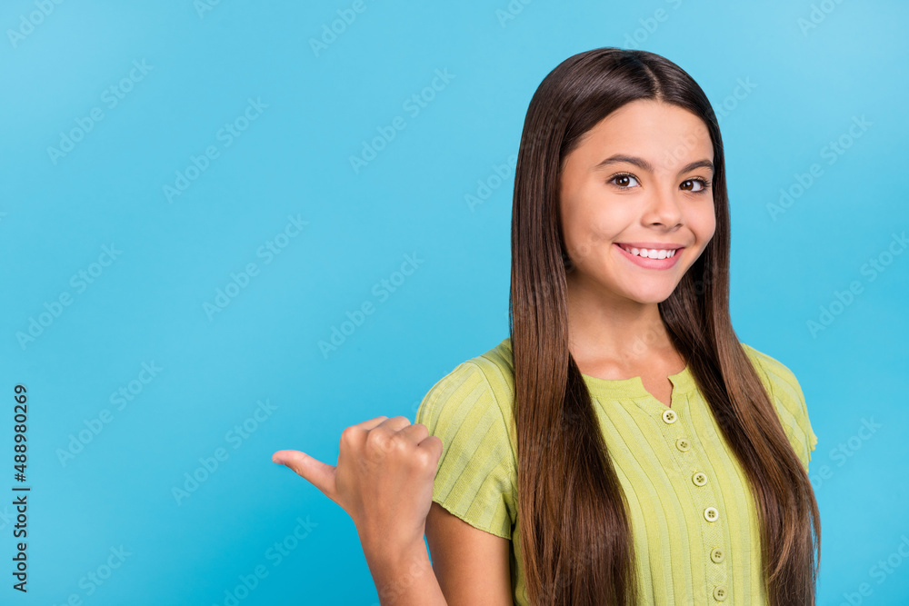 Photo of little lady direct thumb side empty space proposition wear green top isolated blue color background
