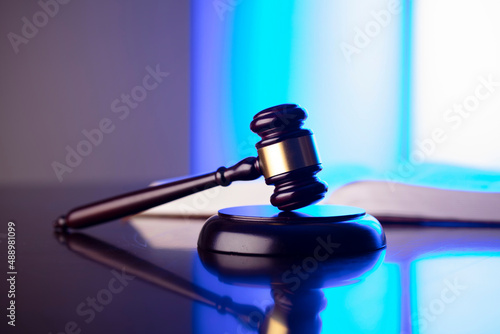 Law concept. Gavel, Themis sculpture and law code in lawyers office. Bluelight background.