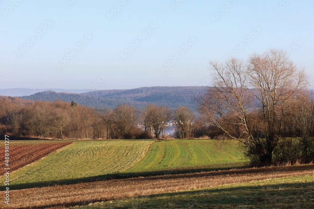 Feld mit einem Dorf im Hintergrund.
