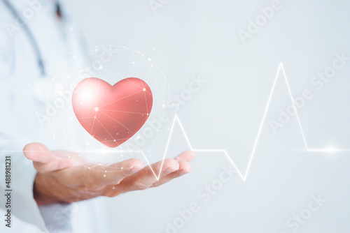 Medicine doctor holding red heart with innovative technology and medicine concepts.