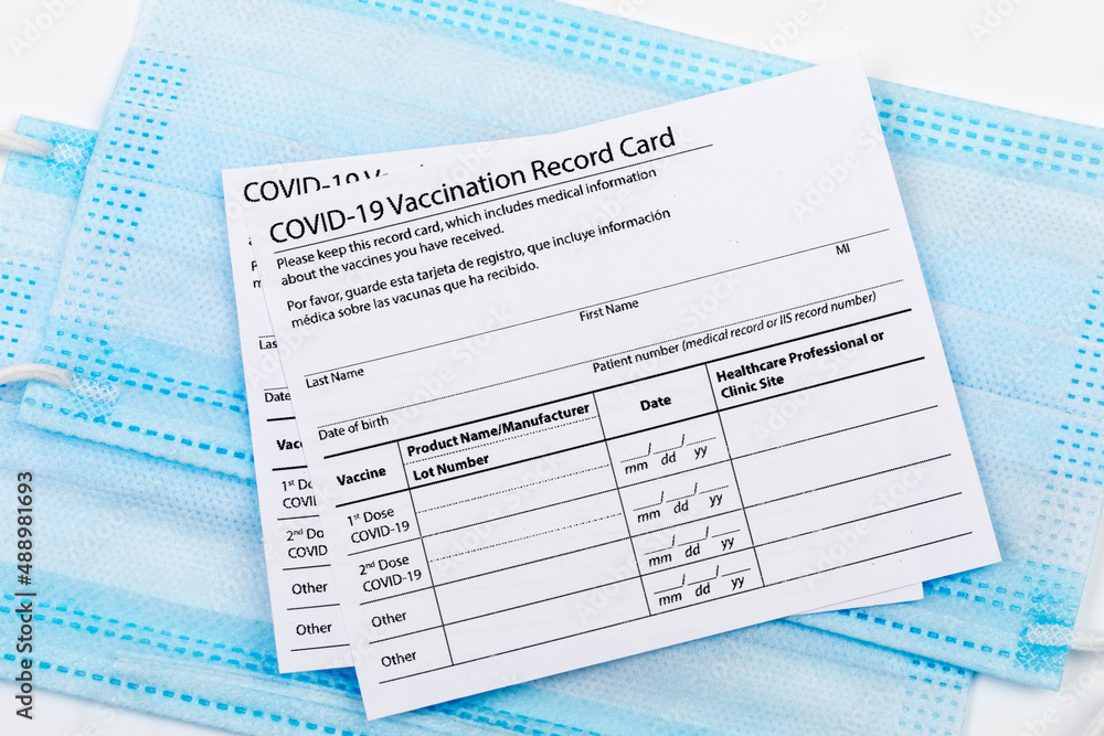Obraz premium Coronavirus vaccination record card. Protective mask divided into two parts. Concept of defeating Covid-19 - Image