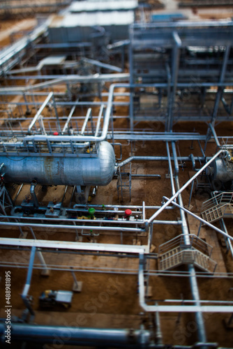 Grey metal pipes of oil refinery plant in the yellow desert. Tilt-shifted partially blurred photo. CNPC company, Kazakhstan, Kyzylorda region.