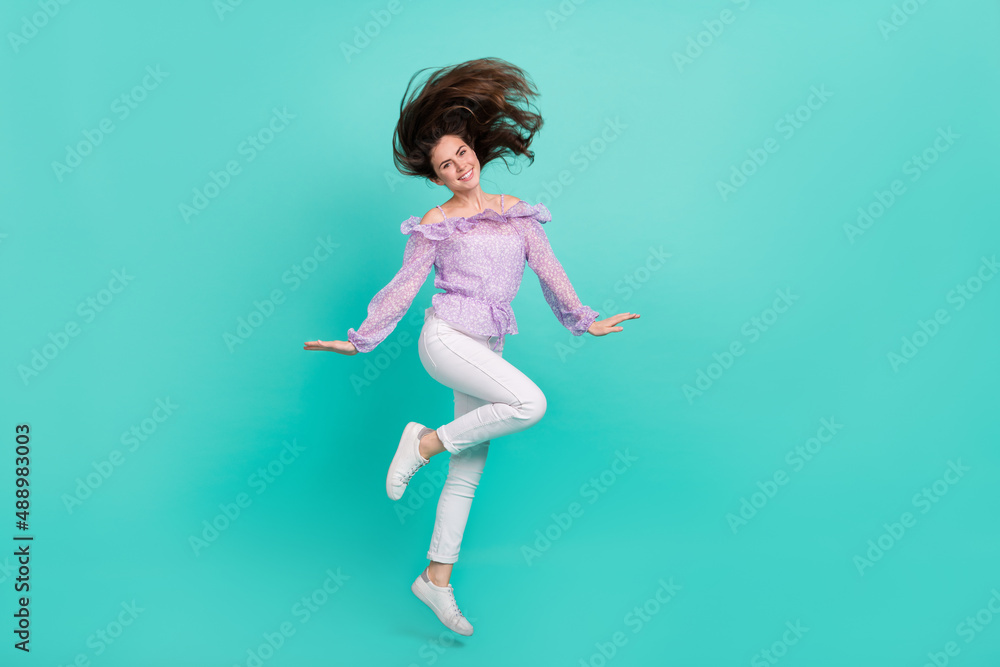 Full size photo of pretty adorable girl flying hair good mood free time isolated on turquoise color background