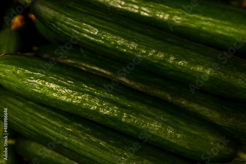 Long fresh cucumbers on the counter in the store. Healthy food and vitamins. Close-up.