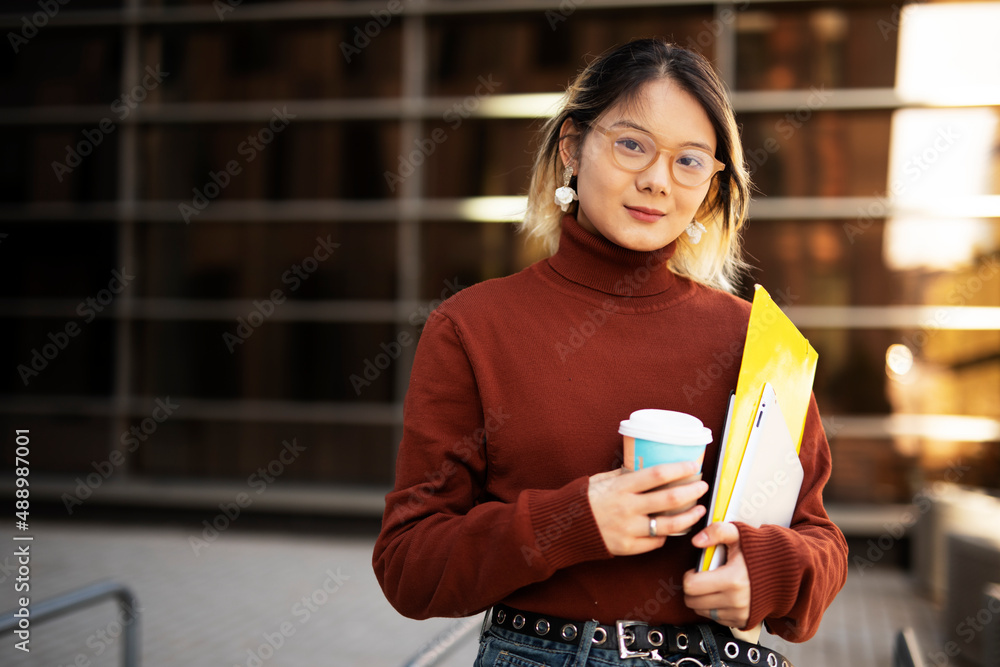 Beautiful Chinese woman enjoy in fresh coffee. Young fashion woman holding coffee cup while walking aroung the city