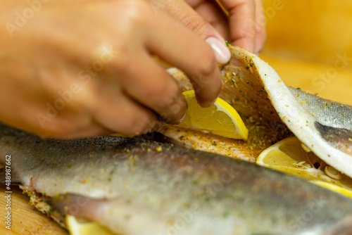 Faszerowanie ryby przyprawami oraz cytryną.